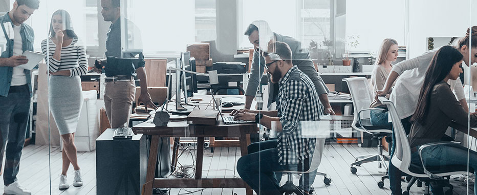 Busy modern office with diverse employees working at desks and collaborating - https://www.jjinsure.com/