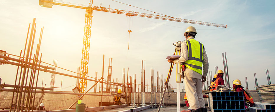 Construction workers wearing safety gear working on a building site - www.jjinsure.com/